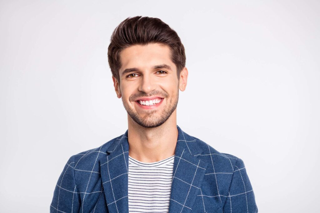 Ο άνδρας αποδεικνύει την ανακούφιση και την επιτυχία της εξαγωγής δοντιού στην κλινική.