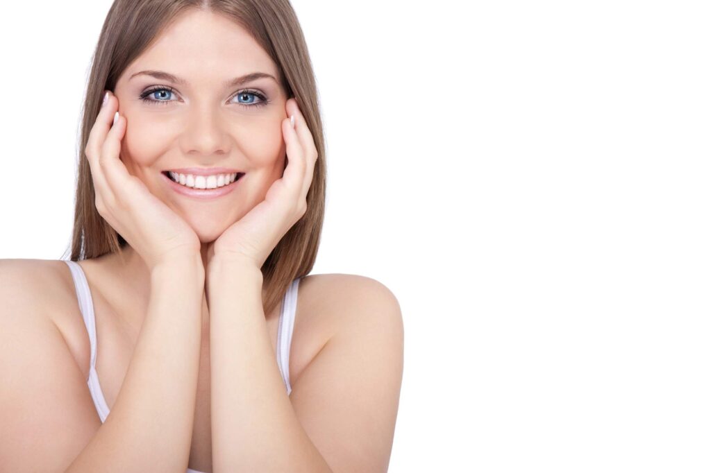 Η γυναίκα χαμογελά δείχνοντας το άνοιγμα του στόματος που μπορεί να επηρεαστεί από την αρθρίτιδα κροταφογναθικής άρθρωσης.