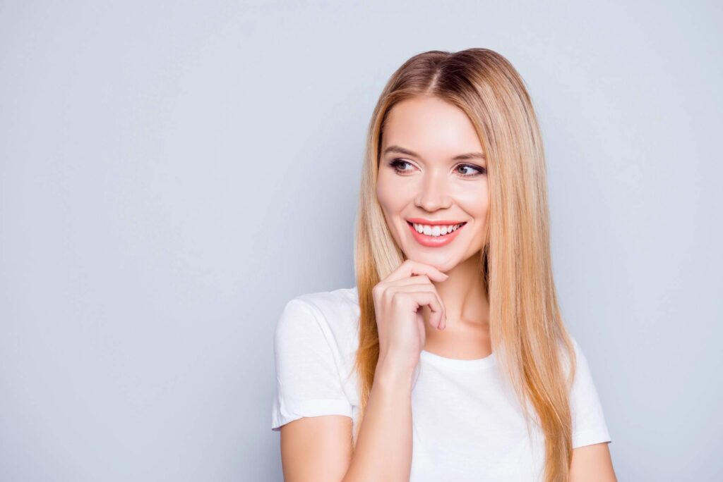 Η γυναίκα δείχνει το χαμόγελο που μπορεί να επηρεαστεί από τον βρυγμό και το σφίξιμο των δοντιών.